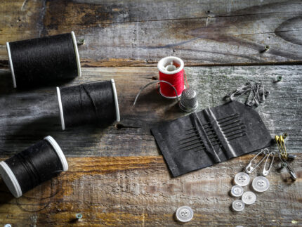 set of sewing threads and accessories on wooden background