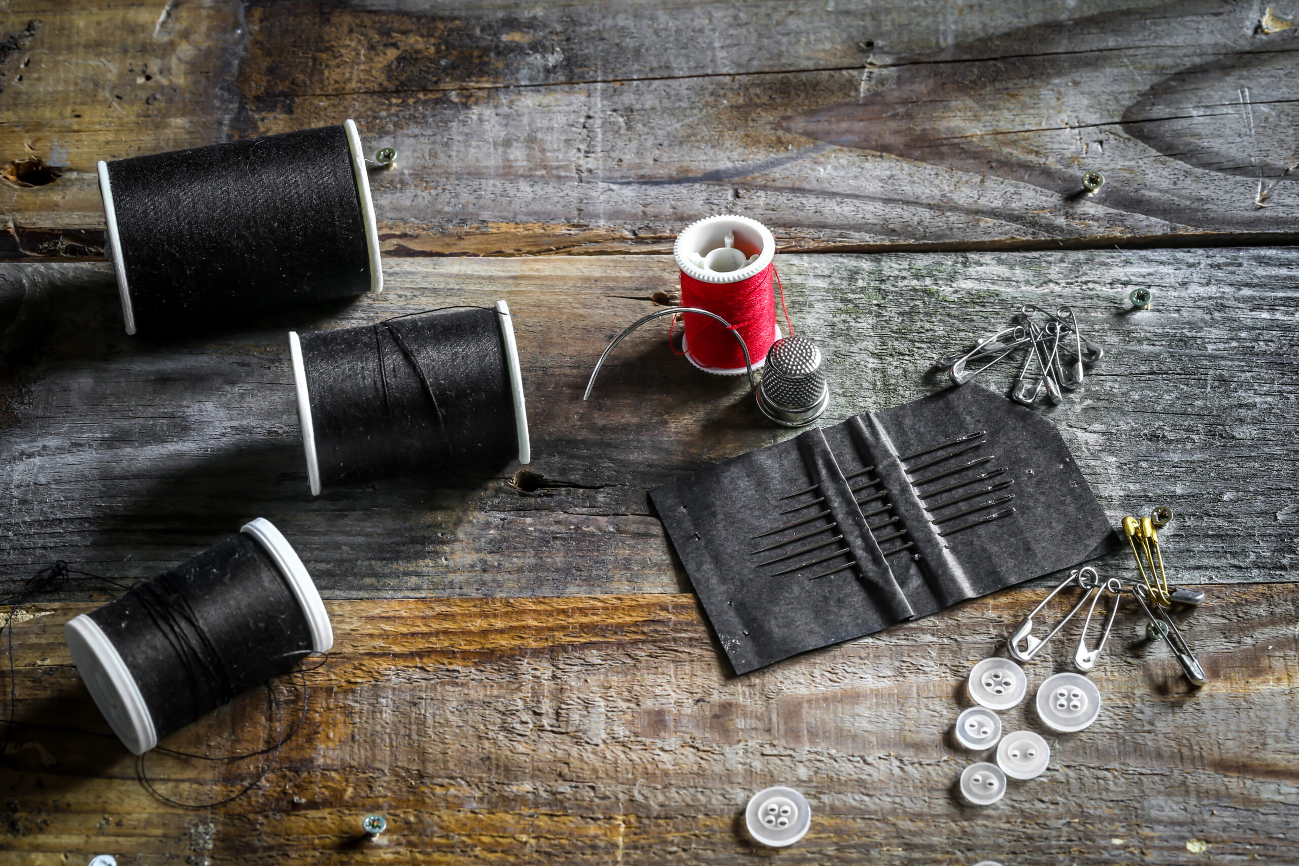 set of sewing threads and accessories on wooden background