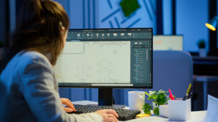 over the shoulder shot of engineer working with architectural plans